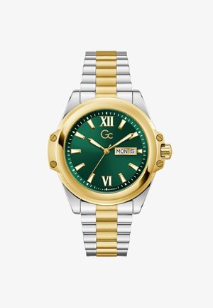 Arany és ezüst növényi acél karóra zöld számlappal, római számokkal, dátumkijelzővel és két tónusú szíjjal, amelyszálcsiszolt és polírozott láncszemeket tartalmaz.