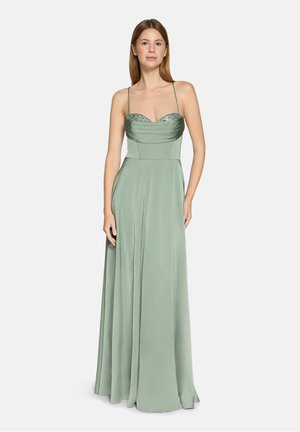 Długa, miętowozielona wieczorowa suknia z dopasowanym gorsetem, dekoltem w kształcie serca i cienkimi ramiączkami. Górna część zdobiona marszczeniami i ozdobami.