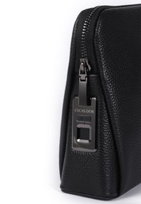 Borsa in pelle nera testurizzata con una forma elegante e angolare, hardware metallici con zip e dettaglio del marchio sul lato.