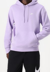 Violetti huppari, valmistettu puuvillasekoitekankaasta, jossa edessä tasku, kiristysnyörit hupussa ja pieni valkoinen Nike-logo rinnassa.