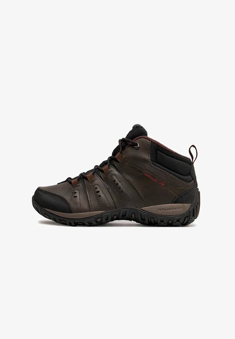 Zapato de senderismo de medio altura en marrón y negro, con cordones en la parte delantera, cuello acolchado, suela resistente y tirador en el talón.