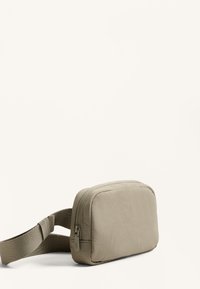 Borsa rettangolare grigia chiara con una texture liscia, chiusura con zip e una larga tracolla regolabile. Design minimalista senza motivi visibili.