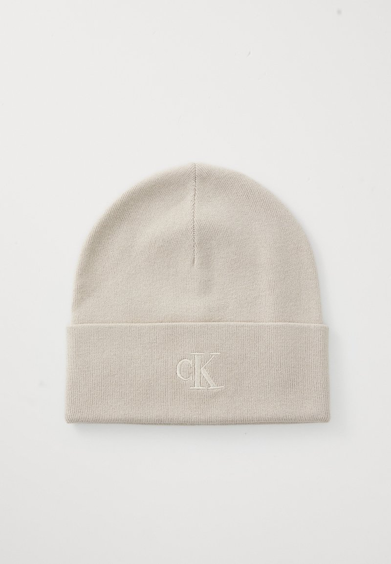 Bonnet en tricot beige clair avec bord replié présentant une broderie discrète en relief du logo "cK" au centre avant.