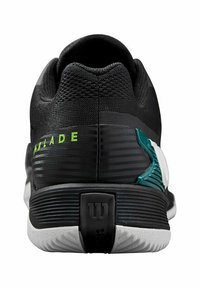 Schwarzer Sportschuh mit einer strukturierten Strickoberfläche, grünen Akzenten und einer weißen sowie türkisfarbenen Zwischensohle. Er verfügt über ein auffälliges "W"-Logo an der Ferse.