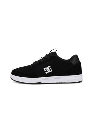 Black suede sneakers with a white rubber sole, featuring a rounded toe, lace-up design, and a prominent DC logo on the side.
