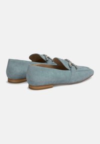 Lichtblauwe suede instappers met een lage hak, voorzien van een decoratieve versiering aan de voorkant en een gladde textuur.