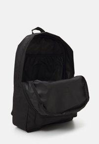 Mochila preta com um grande compartimento principal, bolso frontal com fecho e tecido durável. Textura suave com um design simples e funcional.