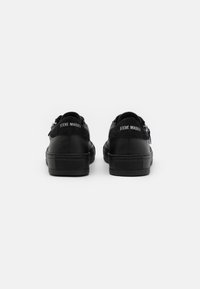 Schwarze Sneakers mit einem glatten Lederobermaterial und Suede-Akzenten. Hervorstechende Markenkennzeichnung an der Ferse und eine strukturierte Gummisohle.