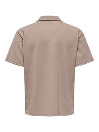 Polo beige à manches courtes vu de dos avec un col classique et une texture unie.