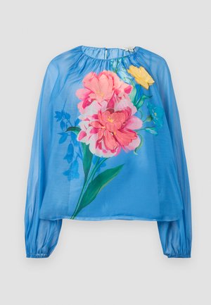 Blouse légère bleu clair en tissu transparent avec des manches longues, ornée de grandes impressions florales en rose, jaune et vert. Poignets élastiqués et encolure froncée.