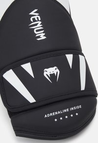 Black training mitt with a smooth surface, featuring white accents and text. Design includes a snake logo and "ADRENALINE INSIDE" detail.