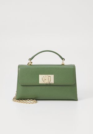 Bolso de cuero verde con asa superior, broche rectangular dorado y correa de cadena dorada parcialmente visible sobre fondo blanco.