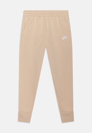 Pantalones jogger color beige, confeccionados en una tela suave, con cintura elástica, bolsillos laterales y un logo de Nike en blanco en la pierna izquierda.