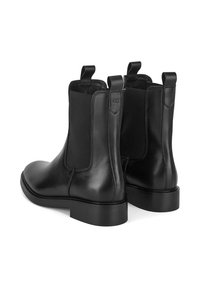 Mustad mustad Chelsea saapad elastsete külgpaneelidega, ümarate varvastega ja tagaküljel tõmbenööridega. Sile viimistlus ja madal, tugev konts.