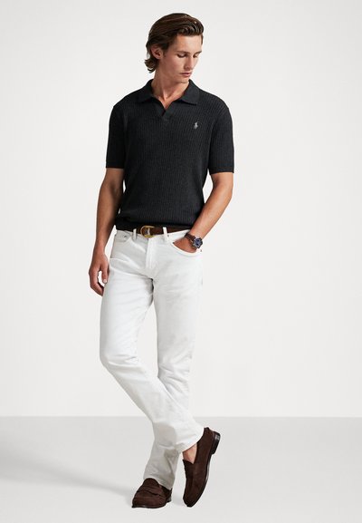 Μαύρο ριγωτό πόλο μπλουζάκι, λευκά παντελόνια slim-fit, καφέ σουέντ μοκασίνια και ζώνη. Ρολόι με στρογγυλό καντράν και πολύχρωμο λουράκι.