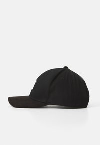 Gorra negra de algodón con visera curva en negro y marrón oscuro. Presenta una corona redondeada y seis ojales de ventilación.