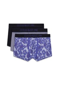 Trois caleçons pour hommes empilés ; un motif floral aux tons violets, un gris uni et un noir uni, tous avec une ceinture noire portant l'inscription « GUESS EST. 1981 ».