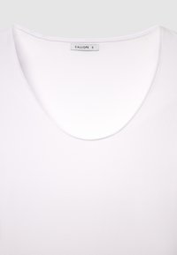 Camicia bianca a maniche corte con scollo a V profondo. Realizzata in tessuto morbido; presenta un'etichetta con la scritta "CALLIOPE S.". Tessuto liscio in tutta la superficie.