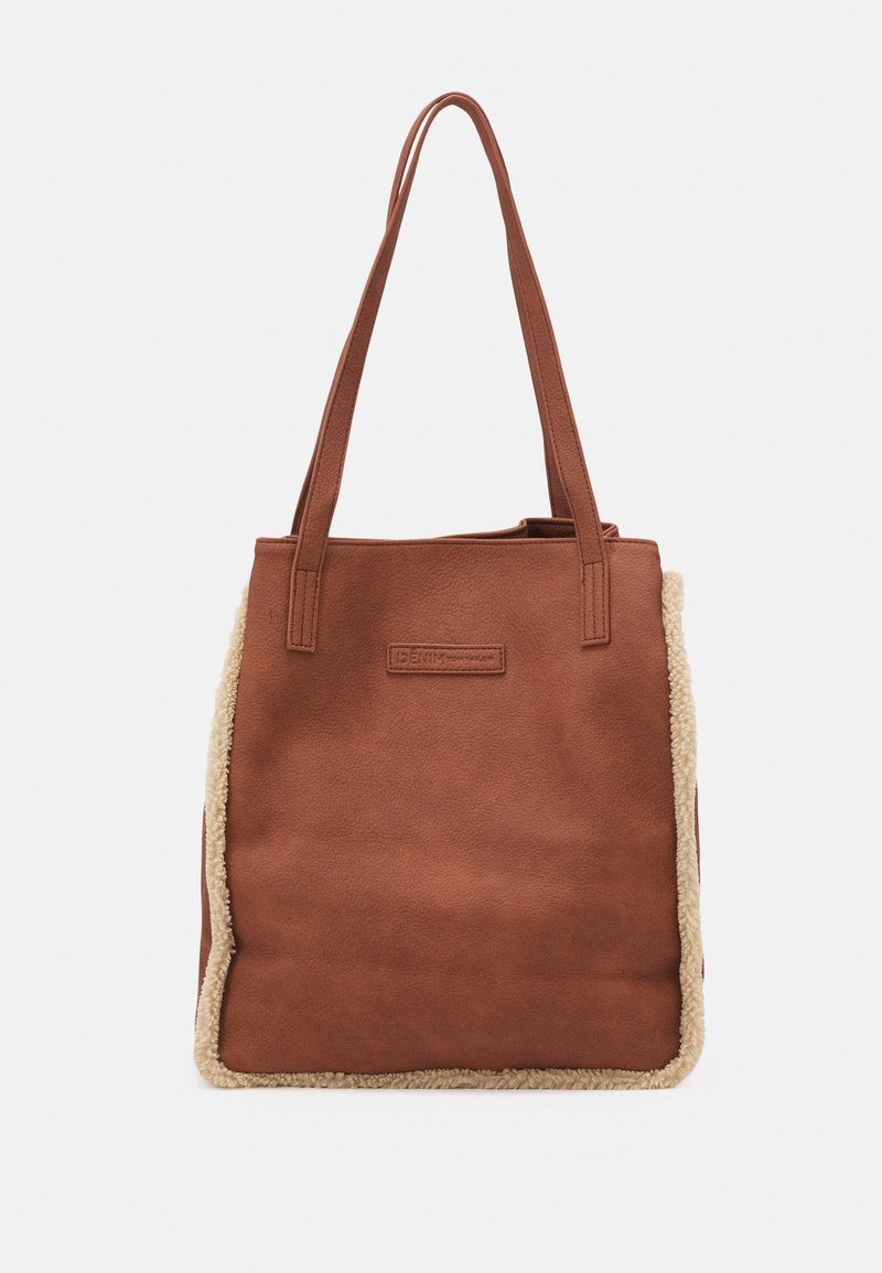 Sac fourre-tout marron avec longues anses, matériau à texture douce, et bordure en polaire beige le long des côtés et des bords inférieurs.