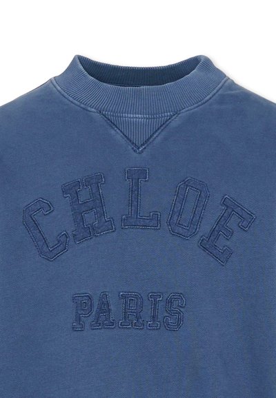 Niebieska bluza z prążkowanym, okrągłym dekoltem. Z przodu haftowany napis "CHLOE PARIS" w ciemniejszym odcieniu niebieskiego. Miękka w dotyku, o casualowym stylu.