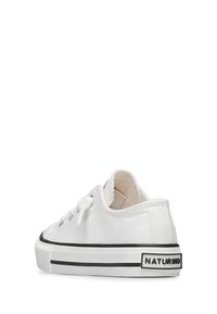 Białe płócienne trampki z okrągłym czubkiem, czarne akcenty na podeszwie i pięcie, z oczkami i sznurowadłami do zapięcia. Metka marki na pięcie.