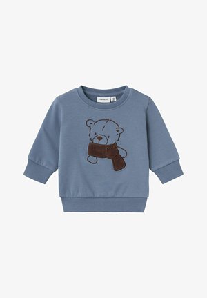 Felpa blu realizzata in morbido cotone, con un orso ricamato marrone che tiene una sciarpa marrone. Dettagli con polsini e bordo a costine.