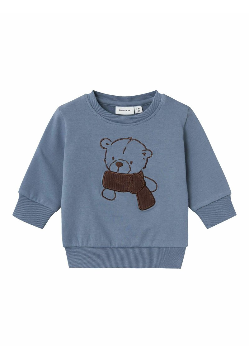 Felpa blu realizzata in morbido cotone, con un orso ricamato marrone che tiene una sciarpa marrone. Dettagli con polsini e bordo a costine.
