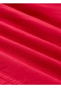 Tissu rose vif avec une texture lisse, présentant des plis doux et un éclat subtil, mettant en avant une couleur uniforme sans motifs ni accents.