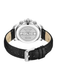 Reverso de reloj en tono plateado con un diseño circular decorado, que presenta la palabra "POLICE". Correa de cuero negro con una hebilla plateada.