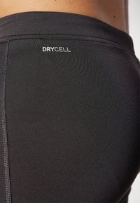 Čierne športové šortky vyrobené z hladkej, elastickej tkaniny, s detailom švu a bielym logom "DRYCELL" na páse.