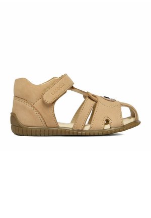 Beige Sandale für Kleinkinder mit Klettverschluss, geschlossenem Fersenbereich, ausgeschnittener Zehenpartie und flexibler brauner Gummisohle.