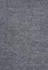Tejido de punto gris con una textura fina, que presenta un patrón uniforme. El material parece suave y ligeramente elástico.