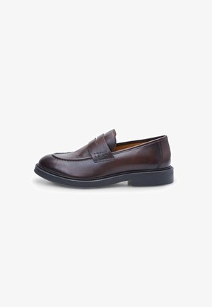 Mocassin en cuir marron avec une texture lisse, un bout arrondi et des détails à double sangle ; doté d'une semelle en caoutchouc noir et d'accents cousus.