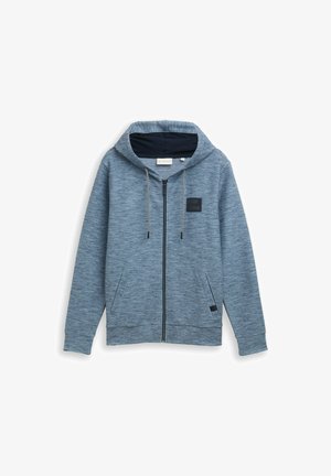 Zippered blue hoodie with a textured fabric, adjustable drawstrings, side pockets, a black badge on the chest, and a fleece-lined hood.