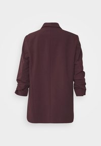 Tummanvioletti bleiseri, jossa on jämäkkä kaulus ja pitkät hihat, kuvattuna takaa valkoista taustaa vasten.