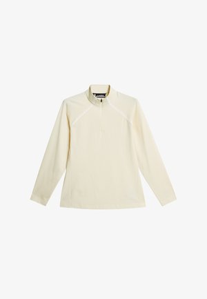 Kremowy pulower z długim rękawem, z suwakiem do ćwiartki długości i stójką, z subtelnymi przeszyciami na ramionach i klatce piersiowej.