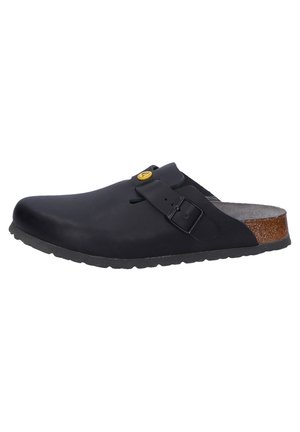Black clogs with a smooth finish, adjustable buckle, cork accent on the heel, and a textured rubber sole for grip and durability.