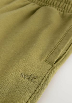 Olijfgroene joggingbroek van zacht materiaal, met een elastische tailleband en een gestikt logo-accent aan de zijkant.