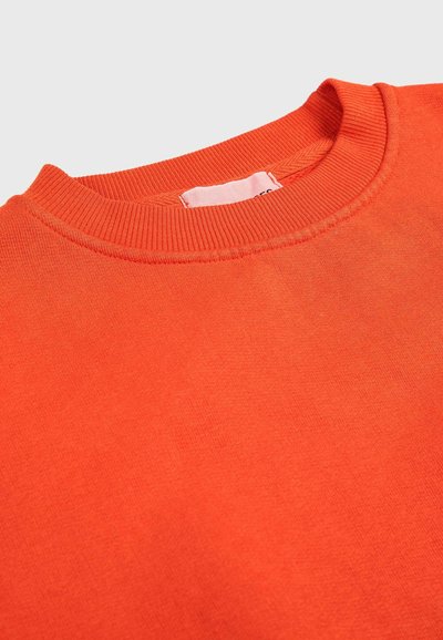 Oranje sweatshirt met ronde hals en ribbelkraag. Gemaakt van zacht materiaal, met een gladde textuur en een klein label bij de kraag.