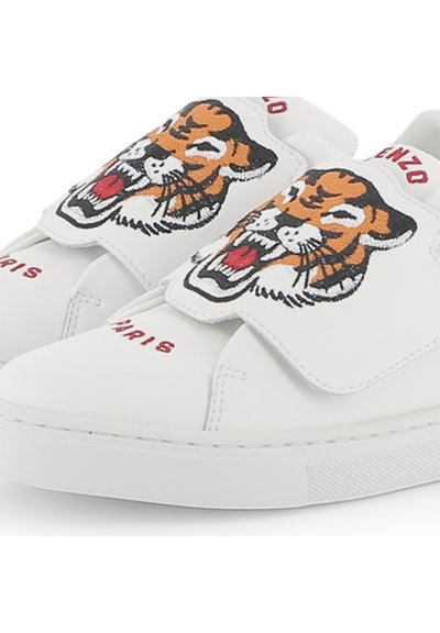 Baskets blanches en cuir ornées d'un design de tête de tigre sur la sangle Velcro, avec "Kenzo Paris" brodé en rouge près de l'orteil.