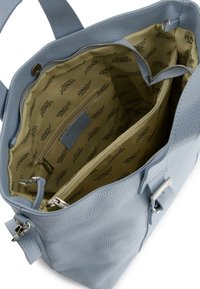 Lichtblauwe leren handtas met een gestructureerd oppervlak, voorzien van een beige voering en meerdere compartimenten, waaronder ritsvakjes.