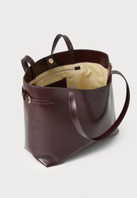 Mørkerød læder tote taske med to håndtag, lynlås lomme, beige indvendig foring og en struktureret form med en flad bund.