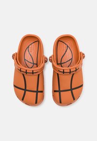 Saboti portocalii cu un model de baschet, având linii negre și suprafețe texturate. Formă rotundă cu bretele ajustabile pe părți.