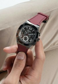 Schwarz Zifferblatt Uhr mit silbernen Akzenten, achteckigem Gehäuse aus Edelstahl und einem bordeauxfarbenen Gummiband. Verfügt über Datums- und Wochentagsanzeigen.