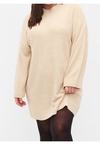 Beżowy, oversize sweter z teksturowanej tkaniny, z prążkowanym dekoltem i mankietami oraz bocznymi rozcięciami dla swobody ruchów.