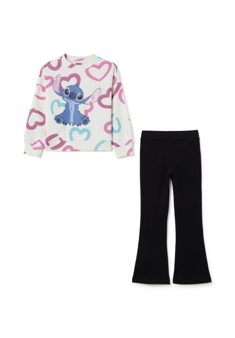 Sudadera en crema con patrones de corazones rosas y azules y un personaje de dibujos animados; combinada con pantalones de campana negros.