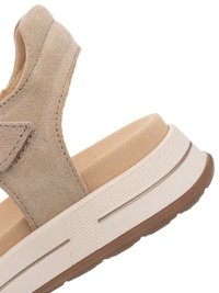 Beige suède sandaal met verstelbare band, gevoerd voetbed en witte rubberen zool met textuurgreep en bruine buitenzool.