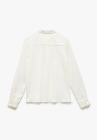Camicia bianca a maniche lunghe con una texture morbida, dotata di colletto, polsini con bottoni e un dettaglio a yoke sul retro.