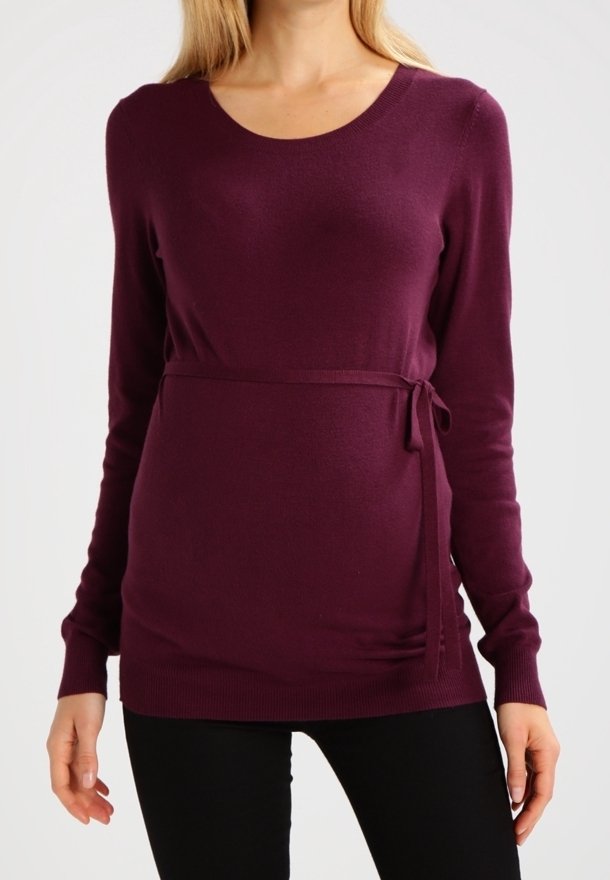 Fioletowy sweter z długim rękawem i okrągłym dekoltem, z detalem w postaci zawiązania w talii oraz miękką, gładką fakturą, w połączeniu z czarnymi spodniami.