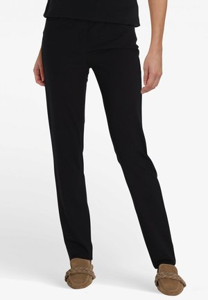Zwarte broek van zachte stof, met een slim fit en een elastische tailleband. Draag met beige instappers voor een ontspannen look.